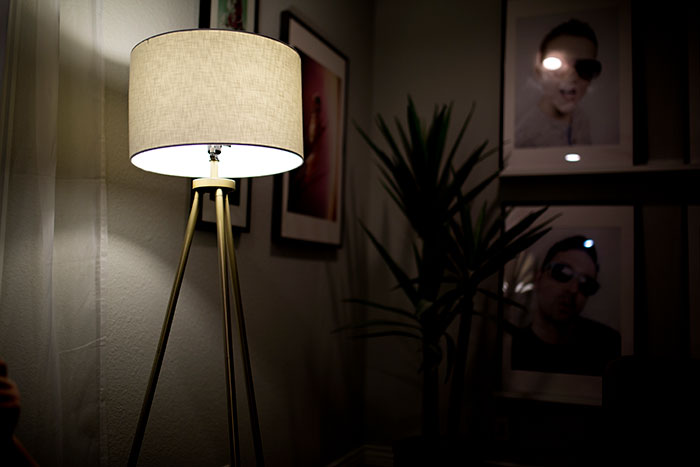 Klimatyczny salon sfotografowany wieczorem w świetle lampy stojącej z abażurem z materiału