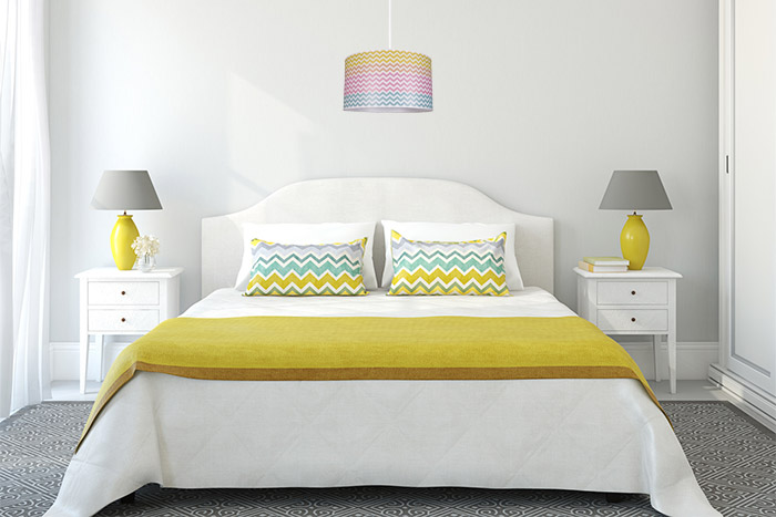 Przytulna jasna sypialnia z żółtymi elementami dekoracyjnymi