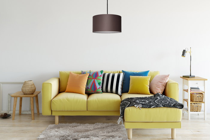 Klasyczna lampa wisząca z brązowym abażurem nad kanapą w pokoju dziennym