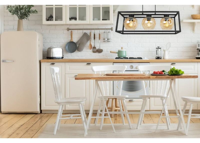 Lampa z 3 miodowymi kloszami i czarną konstrukcją wisząca w kuchni
